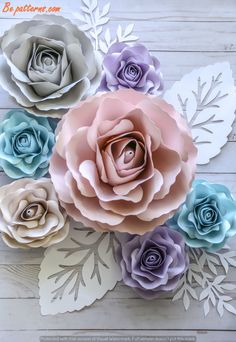 paper flowers are arranged on top of each other, with leaves in the middle and one flower at the bottom