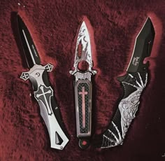 three different types of knives on a red surface