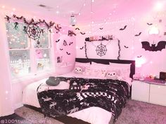 a bedroom decorated in pink and black with bats on the wall, lights strung from overhead