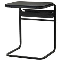 a small black table with a magazine holder on the top and an open drawer underneath it