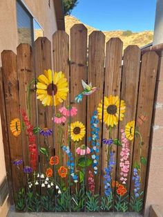 a wooden fence with flowers painted on it