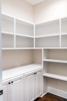 an empty room with white shelves and cupboards