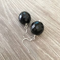 These handcrafted black onyx earrings are simply stunning! Silver fish hooks featuring a large 18mm round faceted black onyx gemstone and measuring 1.5 inches in length. Perfect for any formal occasion! Item is carefully packaged and shipped via USPS in a sturdy protective mailer. Check out more fabulous jewelry and enter my shop here: https://www.etsy.com/shop/jewelbytessyla View the positive feedback I've received from customers and check out some beautiful art prints for nursery and home at m Handmade Black Dangle Clip-on Earrings, Handmade Black Clip-on Earrings For Gift, Elegant Handmade Black Clip-on Earrings, Black Dangle Plug Earrings Nickel Free, Black Dangle Earrings With Ear Wire, Nickel-free Black Dangle Plug Earrings, Black Adjustable Jewelry With Ear Wire, Black Nickel-free Dangle Plug Earrings, Adjustable Black Jewelry With Ear Wire