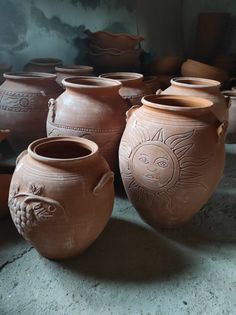 several clay pots are lined up on the floor