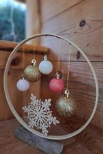 a snowflake ornament is on display in a circular glass holder with ornaments hanging from it