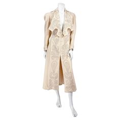 1900s Edwardian cream wool coat adorned with graphic silk soutache embroidery along the modified collar, front panels, sleeve cuffs, and upper back. The embroidery is configured into an Art Nouveau motif. The full length sleeves are finished with a tight cuff and the shoulders are gathered giving the sleeve a little volume. The interior is fully lined in silk satin and the front has a series hook and eye closures. 16 inch shoulder up to 37 inch bust 27 inch waist 37 inch hip 49.5 inch length Vintage Embroidered Formal Outerwear, Vintage Embroidered Outerwear For Formal Events, Cream Wool Coat, Motifs Art Nouveau, Wool Coat, Silk Satin, Length Sleeve, Full Length, Art Nouveau