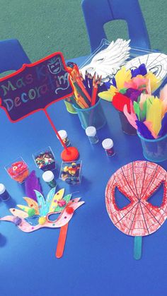 a blue table topped with masks and decorations