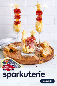 two wine glasses filled with food on top of a wooden tray next to bread and cheese