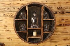 a wooden shelf filled with glasses on top of a wooden wall