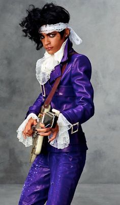 a woman dressed in purple is holding a guitar