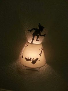 a light that is on the wall with a silhouette of a person holding a broom