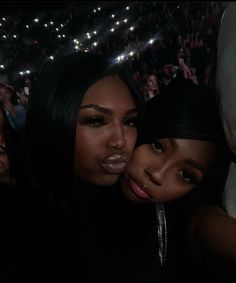 two beautiful young women hugging each other at a concert