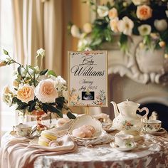 a table topped with tea cups and saucers covered in flowers next to a sign