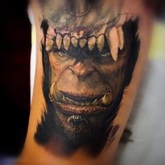 a man's arm with an evil looking tattoo on it