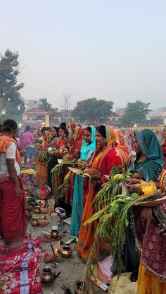 women in colorful sari are selling food