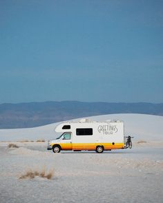 a yellow and white motor home parked in the desert