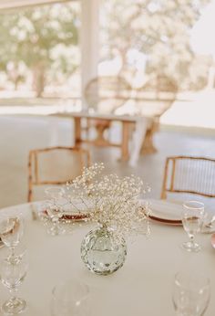 the table is set with white flowers and wine glasses