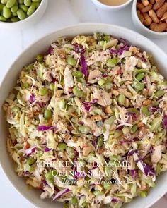 a white bowl filled with coleslaw and nuts next to bowls of green beans