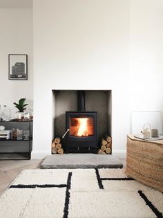 a living room with a fire place and rugs on the floor in front of it