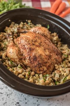 a chicken and rice dish with carrots in the background