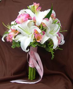 a bridal bouquet with pink and white flowers on a brown satin background for a wedding