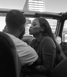 a black and white photo of a woman sitting in the driver's seat of a truck