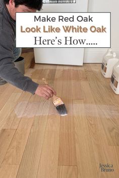 a man is painting the floor with white paint on it and he has a brush in his hand