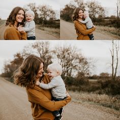 a woman holding a baby in her arms and smiling at the camera while standing on a dirt road