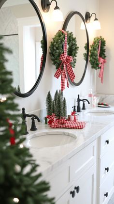 a bathroom decorated for christmas with wreaths and pine trees on the sink counter top