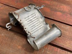 a metal object sitting on top of a wooden table next to a piece of paper