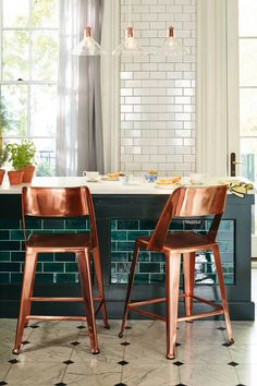 two wooden chairs sitting next to each other in front of a table with plates on it