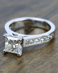 a princess cut diamond ring with channel set diamonds