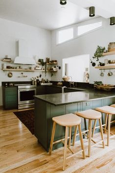 three stools are in front of the kitchen counter