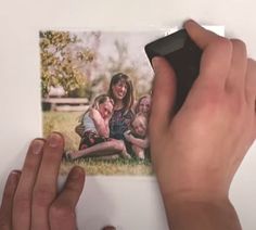 a person holding up a polaroid photo with their hands on the edge of it