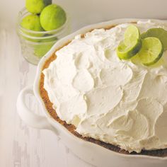 a cake with limes on top in a white dish