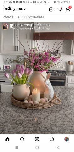 a vase with flowers and candles in it on a counter top next to an oven