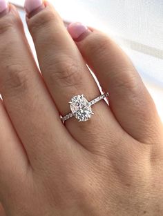 a woman's hand with a diamond ring on top of her finger and the engagement band