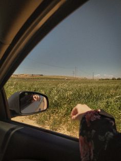 a person's reflection in the side view mirror of a car