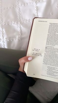 a person is holding an open book in their left hand, with the text written on it