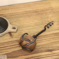 a wooden table topped with a metal hook and a black object on top of it