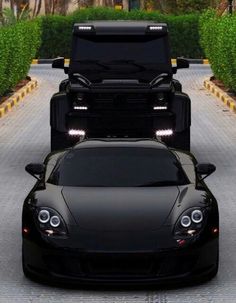 two black sports cars parked in front of each other