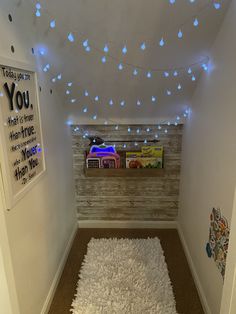 there is a white rug on the floor in this room with lights strung from the ceiling