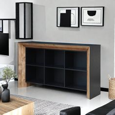 a living room with black furniture and pictures on the wall