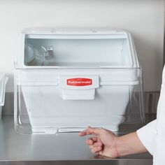 a person pointing at a container on top of a counter