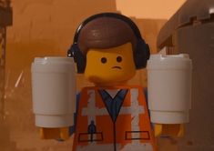 a lego man with headphones holding two cups