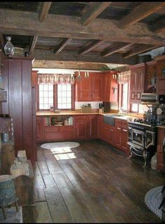 an old fashioned kitchen with wood floors and red cabinets is seen in this image from the inside