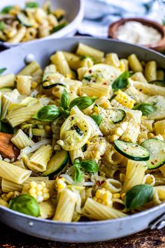 a pan filled with pasta and vegetables on top of a table