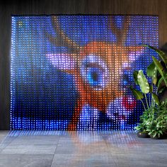 a deer head is projected on the wall next to some plants and potted plants