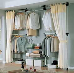 a living room filled with furniture and lots of clothes on hangers next to a window