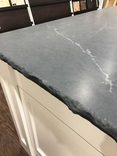 a kitchen counter top that has been painted white and is next to other cabinets in the background